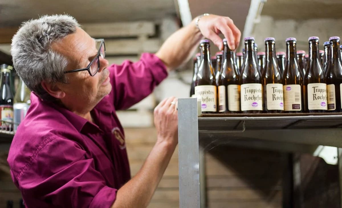 Staff stacking brown beer bottles in the cellar