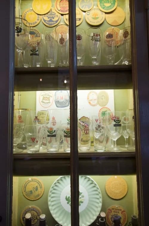 Glass showcase with historical beer glasses and plates